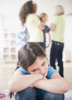 Lonely girl ignoring friends playing