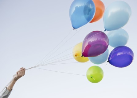 Caucasian woman holding bunch of balloons