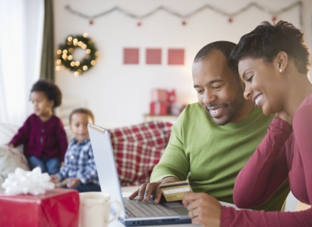 Black mother and father shopping online with credit card