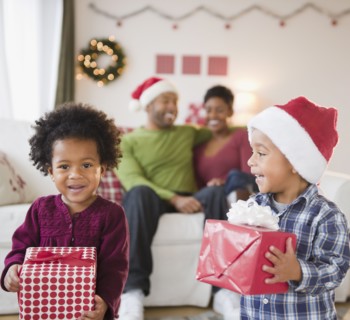 Black brother and sister holding Christmas gifts