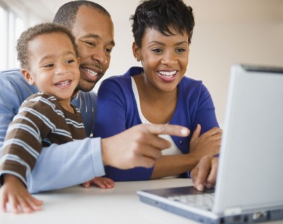 Black family using laptop together