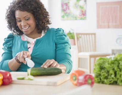 African American woman slicing vegetables