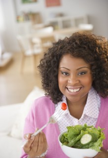 African American woman eating salad