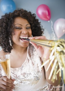 African American woman with noise maker and glass of Champagne