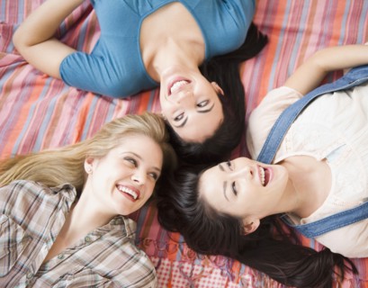 Friends laying on bed together