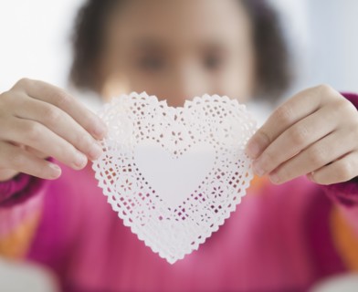 African American girl holding heart-shaped doily