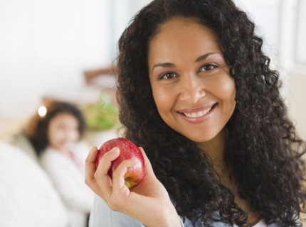 Mixed race woman holding red apple