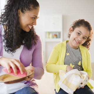 Mother and daughter drying dishes together