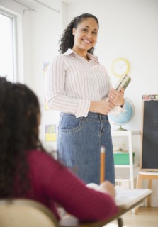 Mixed race teacher smiling in classroom