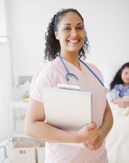Smiling mixed race nurse in hospital room