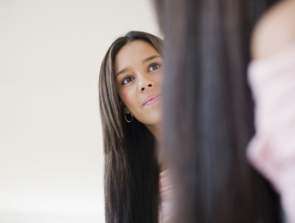 Hispanic teenager looking into mirror