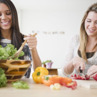 Teenage girls preparing salad together