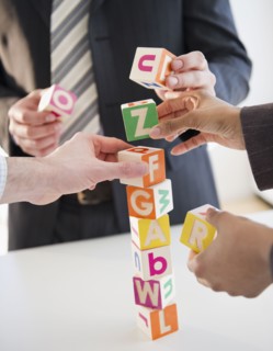 Business people stacking alphabet blocks