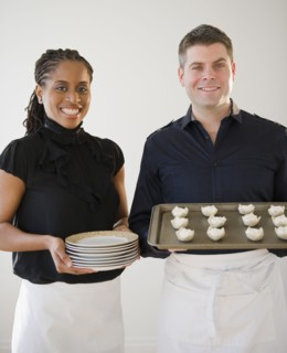Caterers holding plates and tray of food