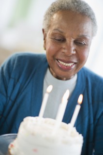 Black woman looking at birthday cake