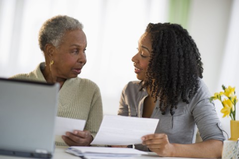 Daughter helping mother pay bills online