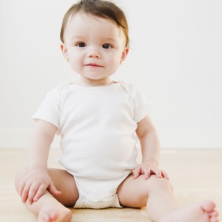 Mixed race baby sitting on floor