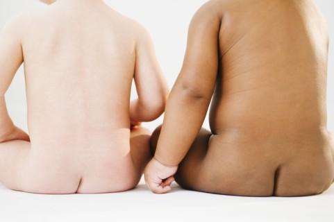 Nude babies sitting on floor