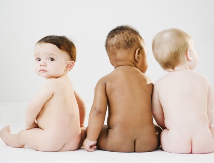 Nude babies sitting on floor