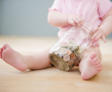 Caucasian baby playing with jar of coins