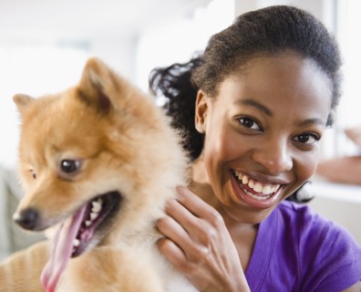 Mixed race woman petting Pomeranian dog