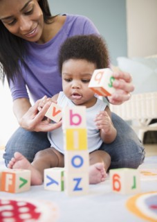African American mother and son playing with alphabet blocks