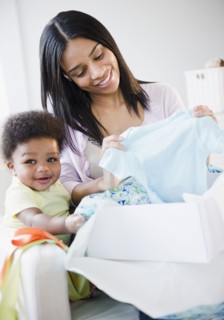 African American mother and baby boy opening gift