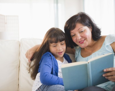 Hispanic mother and daughter reading a book