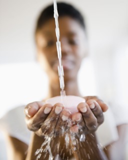 Water splashing on soap in Black woman's hands