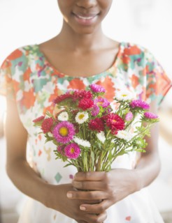 Black woman holding bouquet of flowers