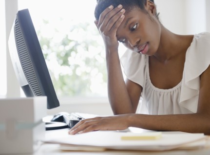 Frustrated Black businesswoman working at desk