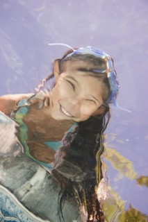 Hispanic girl looking into swimming pool