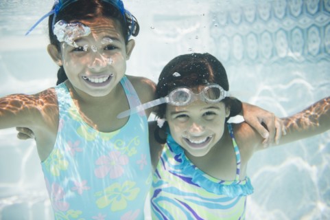 Hispanic girls swimming under water