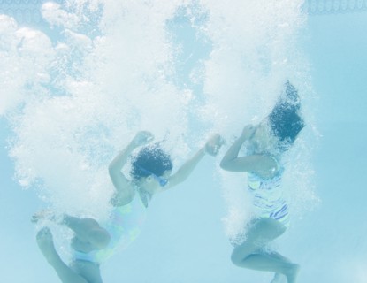 Hispanic girls jumping into swimming pool
