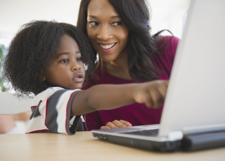 African American mother and son using laptop together