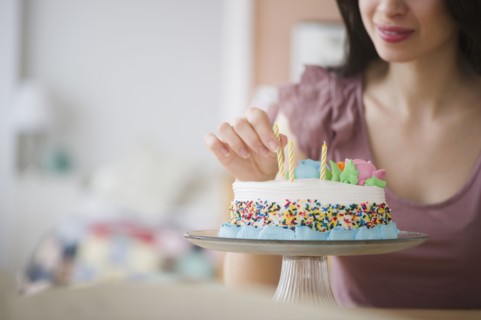 Mixed race woman preparing birthday cake