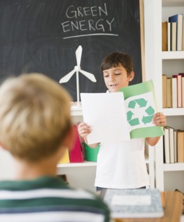 Hispanic boy reading recycling report in classroom