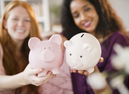 Friends holding piggy banks