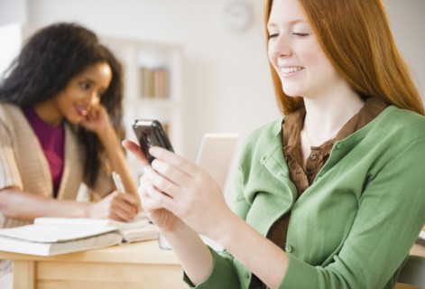 Caucasian woman text messaging on cell phone