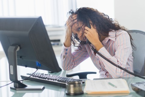 Hispanic businesswoman talking on telephone at desk