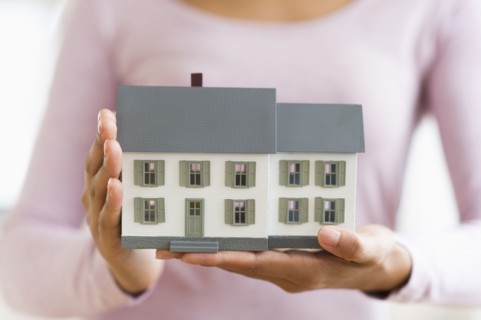 Hispanic woman holding miniature house