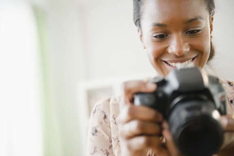 Black woman using digital SLR camera