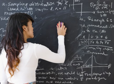 Pacific Islander teacher erasing math from blackboard