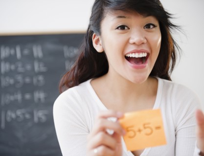 Pacific Islander teacher holding sticky note with math problem