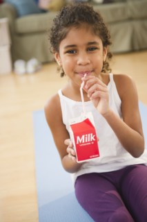 Mixed race girl drinking milk