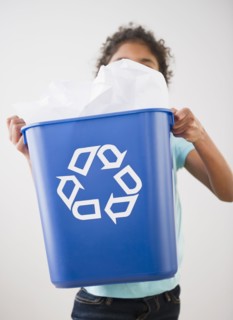 Mixed race girl carrying recycling bin
