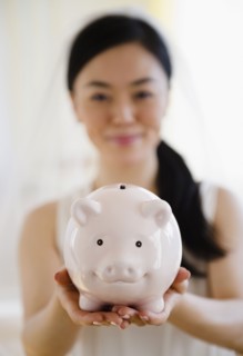 Japanese bride holding piggy bank