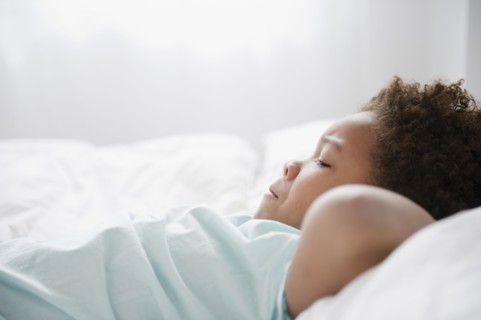 Black boy laying on bed
