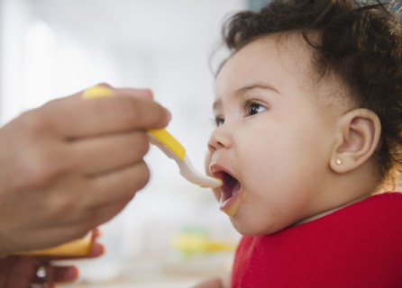 Mixed race mother feeding baby