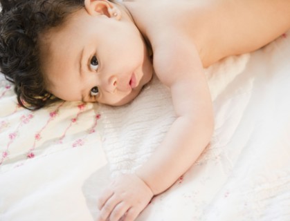 Mixed race baby laying on bed
